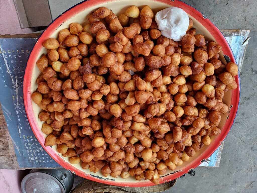 Plateau de yovo doko, beignets béninois dorés et croustillants, vendus dans la rue