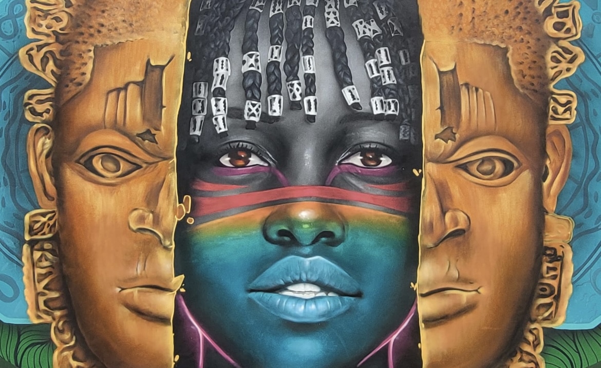 Fresque murale colorée représentant un visage féminin africain stylisé entre deux masques traditionnels, symbolisant la mémoire des ancêtres et l'identité contemporaine