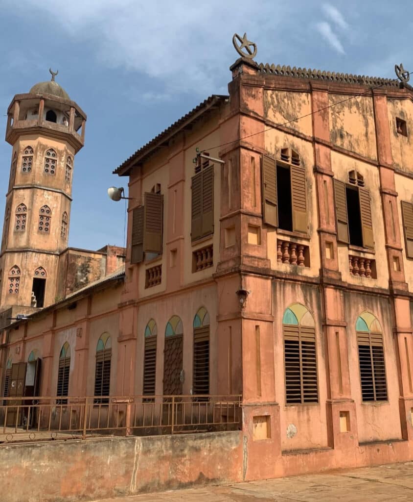 Vieille mosquée en terre cuite avec minaret et volets en bois, située à Alokoegbé au Togo.