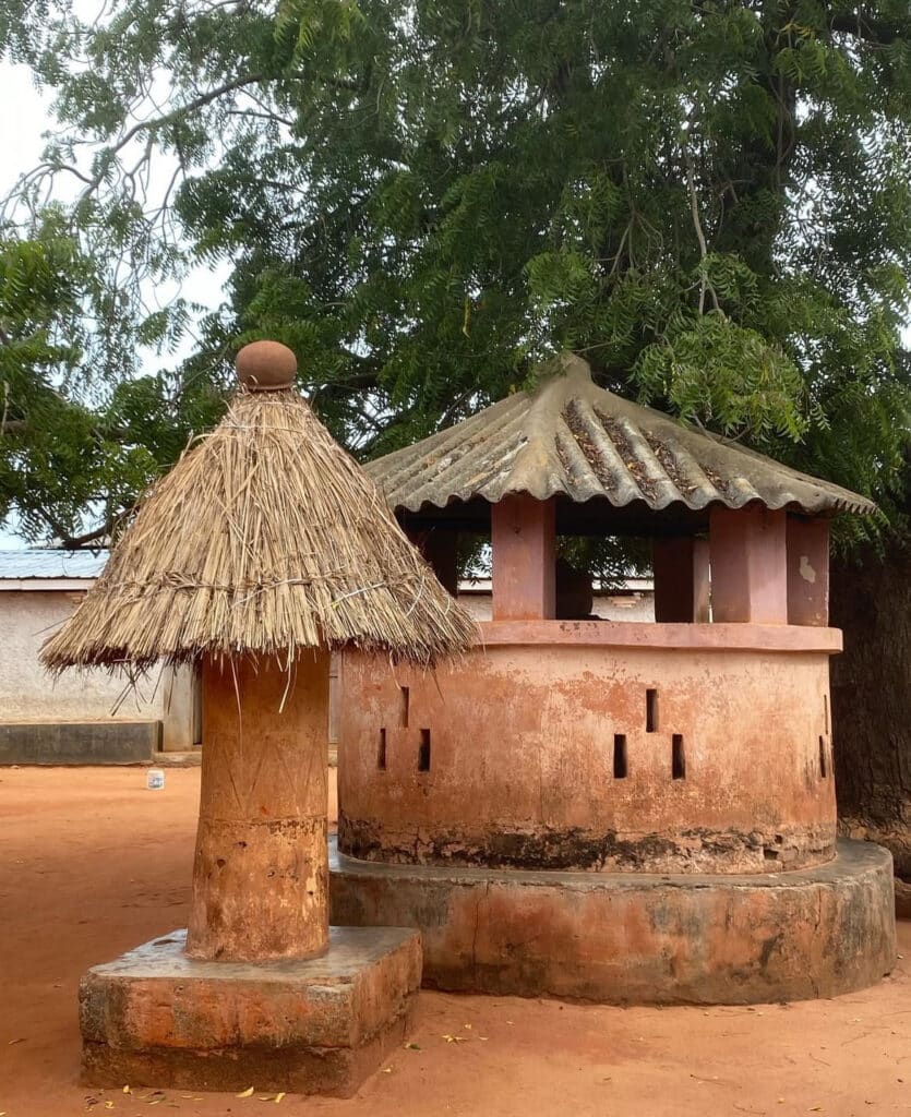 Cases traditionnelles en terre rouge avec toits en chaume et tôle, situées dans un village togolais à Alokoegbé.