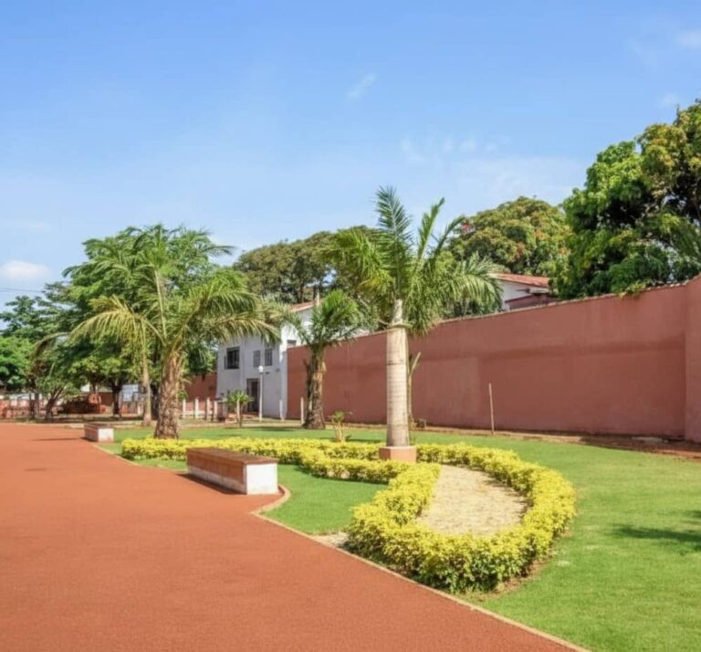 Jardins rénovés et mur d'enceinte ocre du Fort Portugais à Ouidah, site historique majeur du Bénin.