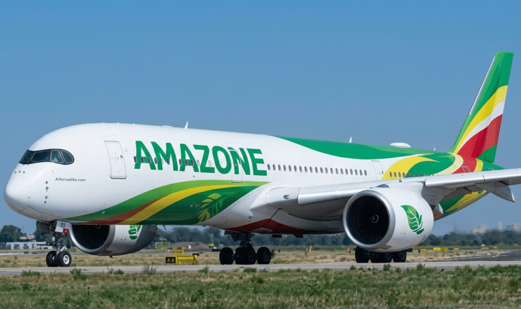 Avion de ligne moderne de la compagnie Amazone Airlines arborant une livrée verte et jaune sur le tarmac d'un aéroport.