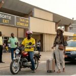 Voyageur arrivant au Bénin avec bagages dans un environnement urbain accueillant