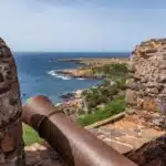 Vue depuis les remparts en pierre du Fortaleza Real de São Filipe montrant un canon ancien pointé vers la côte escarpée et l'océan Atlantique à Cidade Velha, Cap-Vert.
