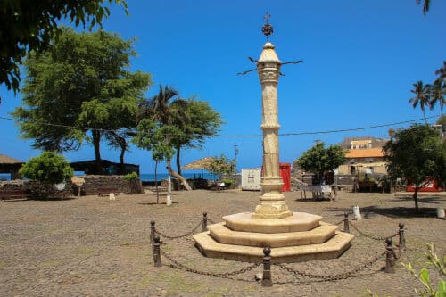 Le Pilori (Pelourinho) historique de Cidade Velha au Cap-Vert, une colonne de marbre blanc sculptée sur une place pavée, symbole du patrimoine mondial de l'UNESCO et de l'histoire coloniale.