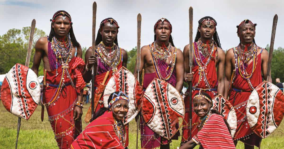 Guerriers Massaï en tenue traditionnelle rouge avec boucliers et lances au Kenya.