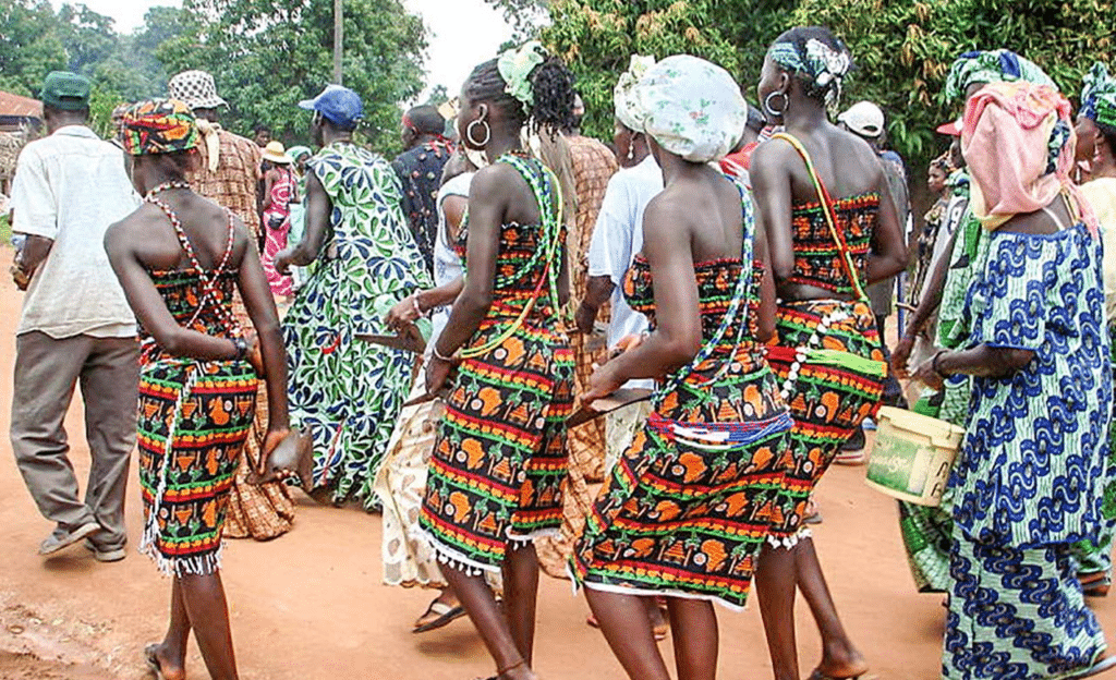 Femmes sénégalaises en tenues traditionnelles colorées marchant lors d'une fête de village.