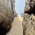 Passage naturel entre deux immenses rochers menant à une plage de sable fin et à l’océan à San-Pédro, en Côte d’Ivoire.